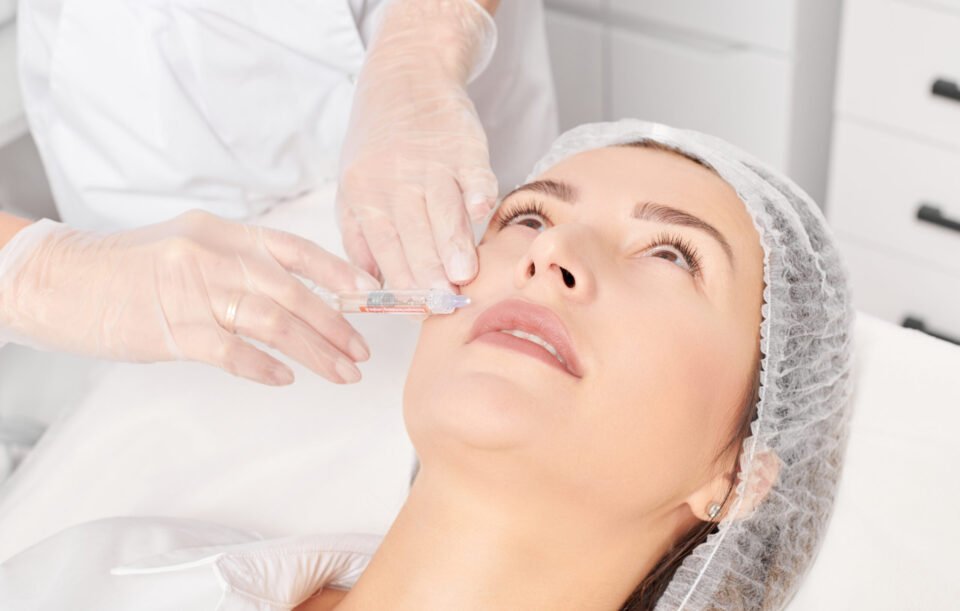 Cosmetologist makes rejuvenation injection in woman face, anti aging procedure in beauty salon